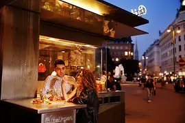 Menschen bei einem Würstelstand 